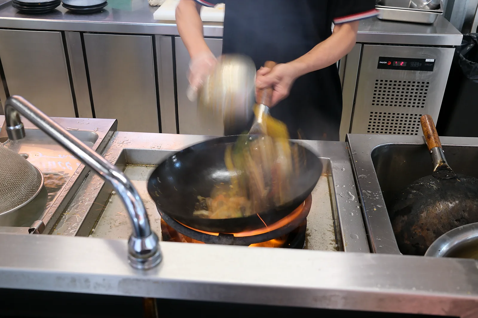 GRILL' INN 厨师正在 Wok 热锅现炒